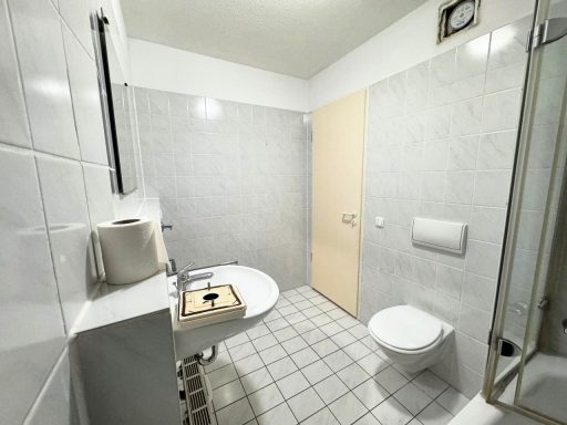 Badezimmer mit weißen Fliesen und vergilbte Tür