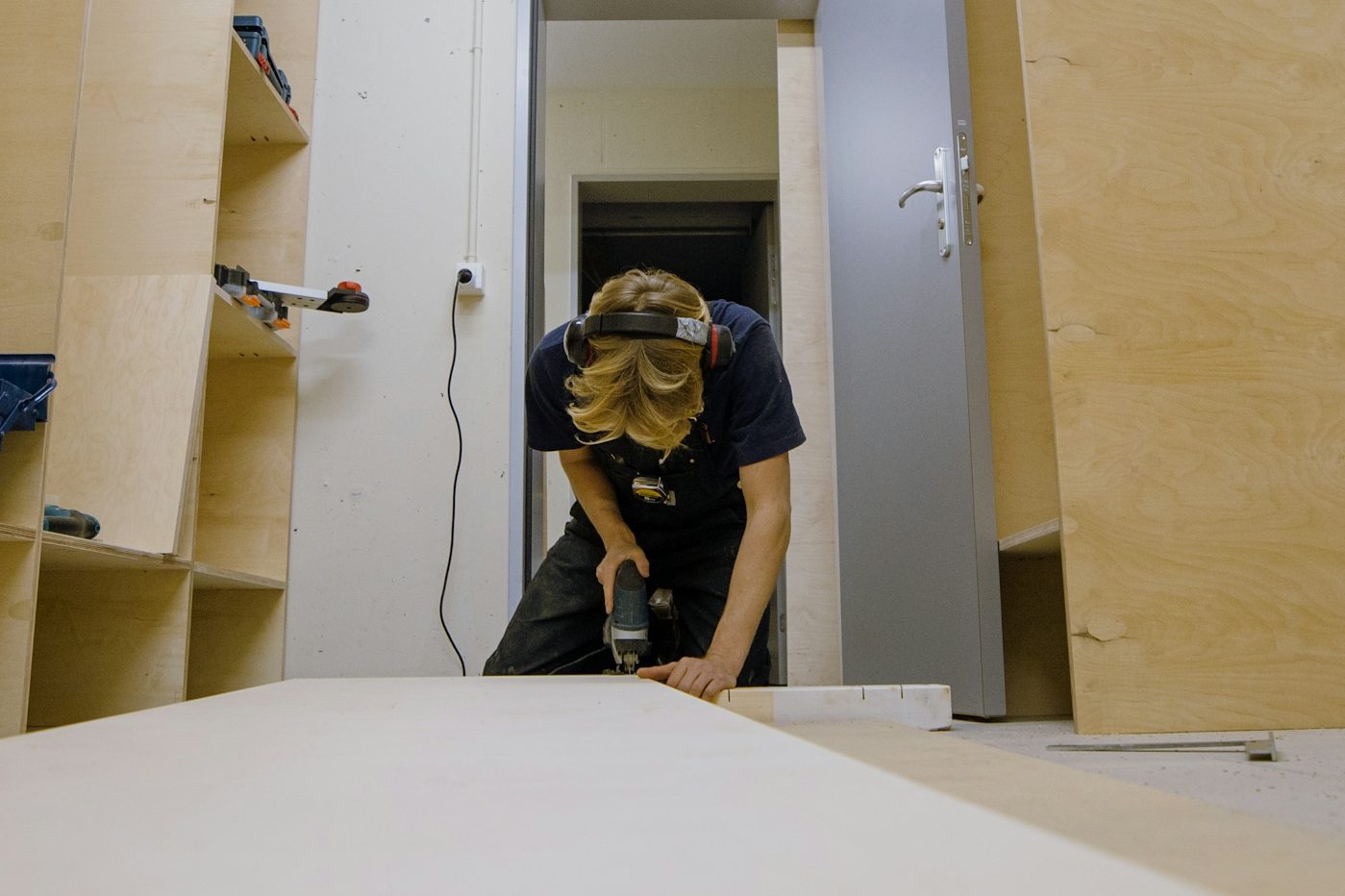 Handwerker sägt mit der Handkreissäge eine Platte in der Werkstatt