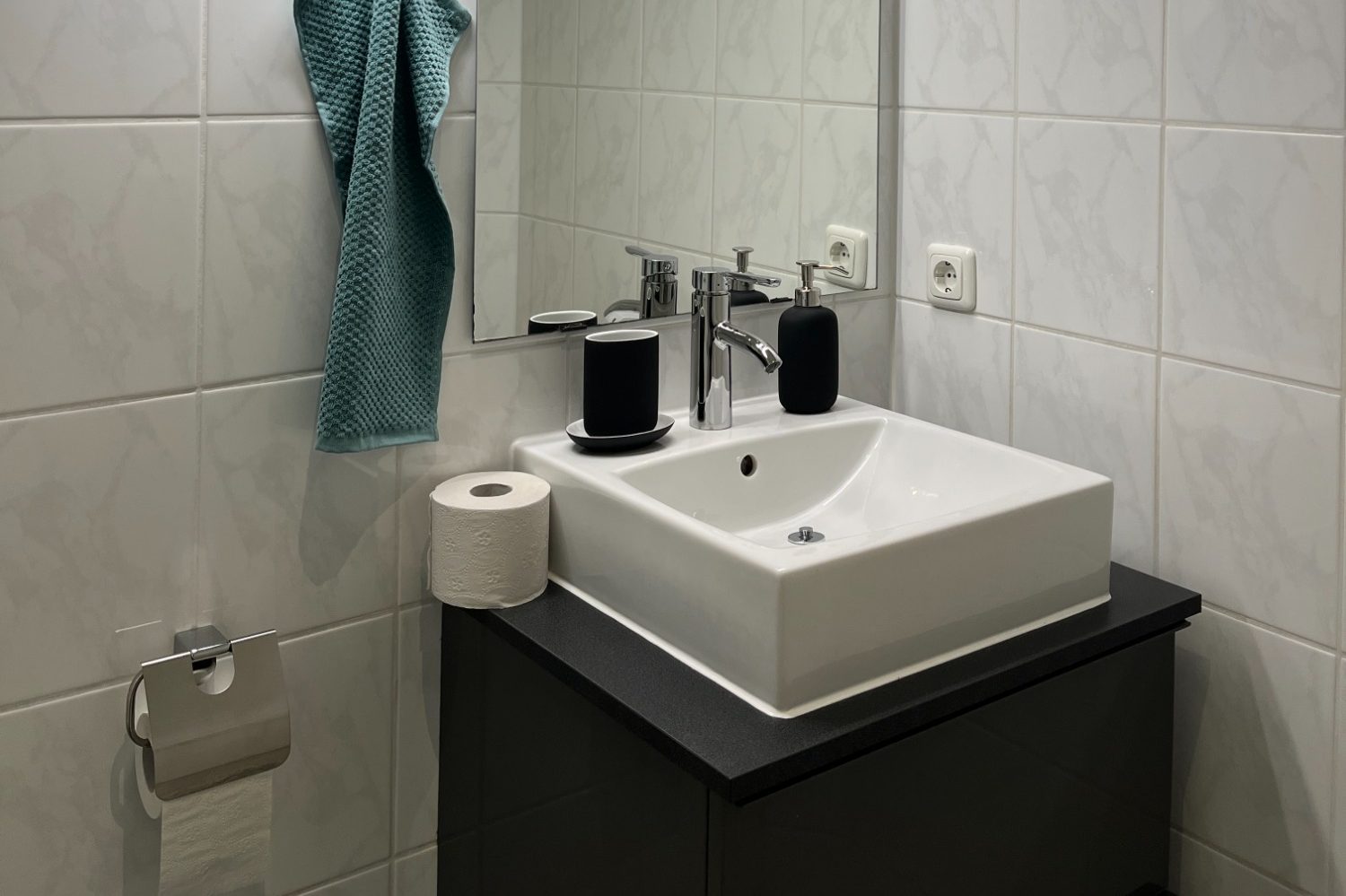 Ein renoviertes Bad mit neuem Spiegel, Waschbecken und Waschtischunterschrank